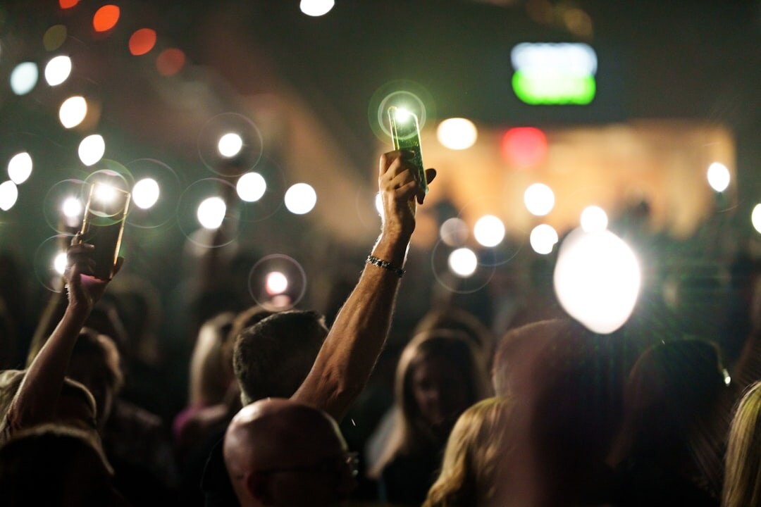 Audience watching a live event with phones raised